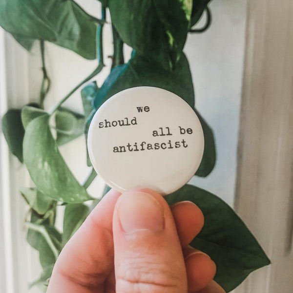 we should all be antifascist typed in typewriter font on a white background, 1.5 inch pinback button 